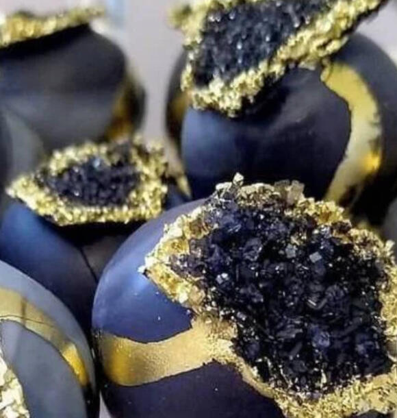 Pixie Dust Truffles Bite-sized chocolates dusted with glittering golden sugar and purple rock candy, filled with raspberry and dark cocoa.