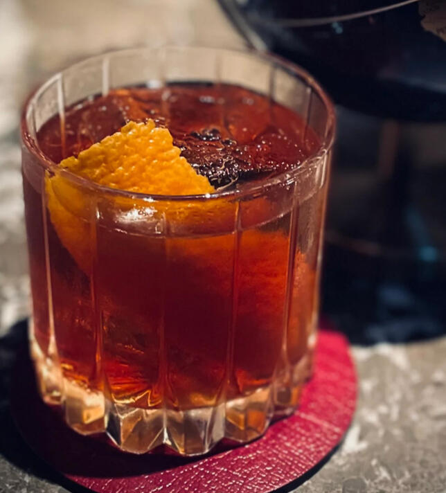 Cauldron&#39;s Flame Dark rum, ginger, lingonberries and charred orange peel served in a smoking glass, warming enough to spark any ritual.